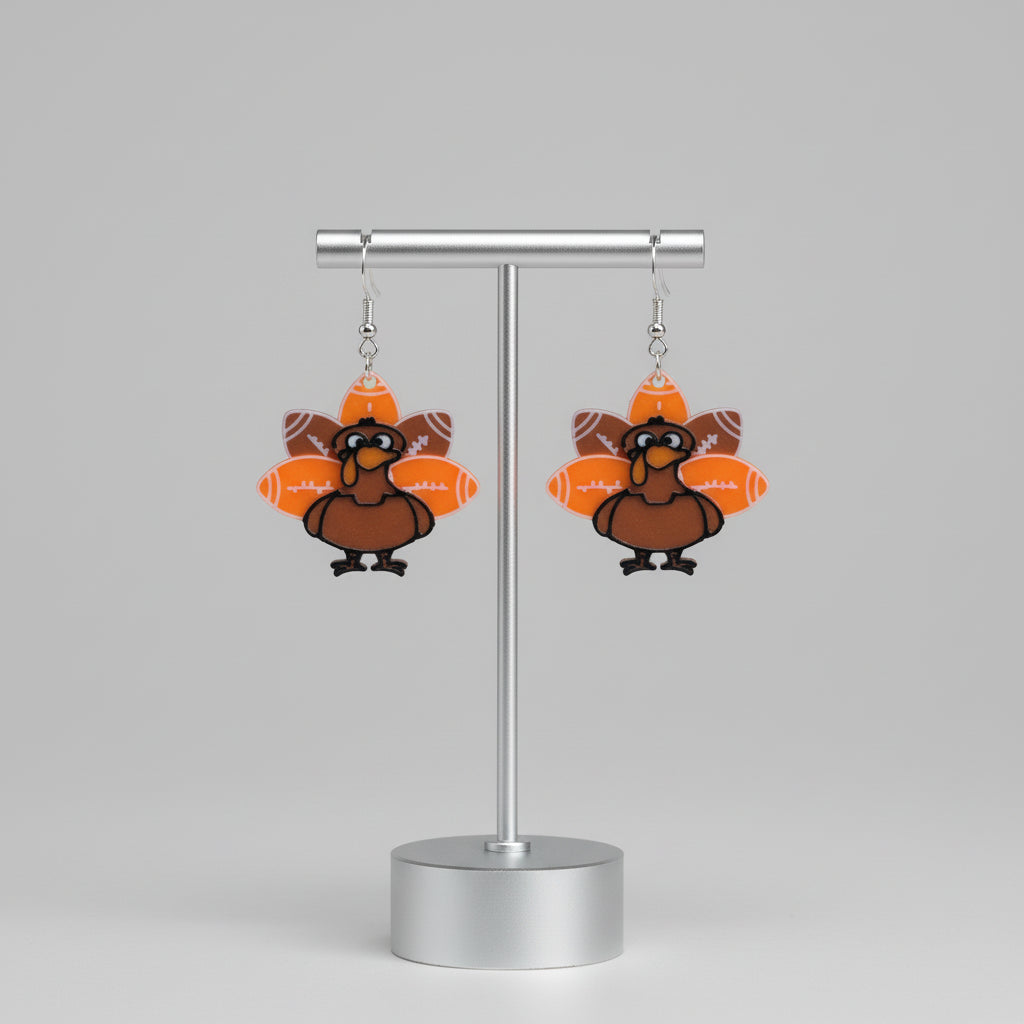 Turkey-shaped earrings on a white stand with a floral background