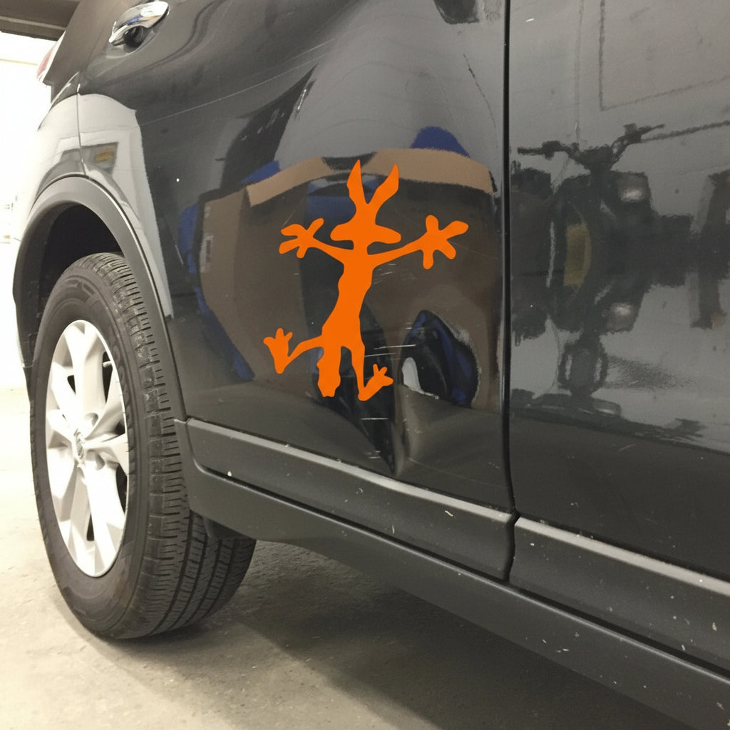 Car side with an orange decal of a stick figure with branches on a reflective surface.