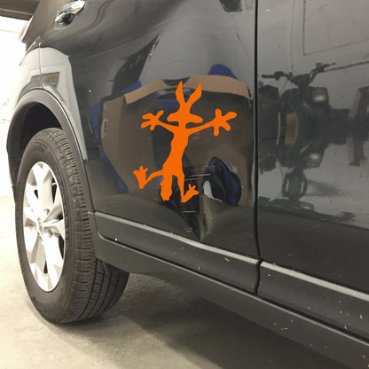 Car side with an orange decal of a stick figure with branches on a reflective surface.